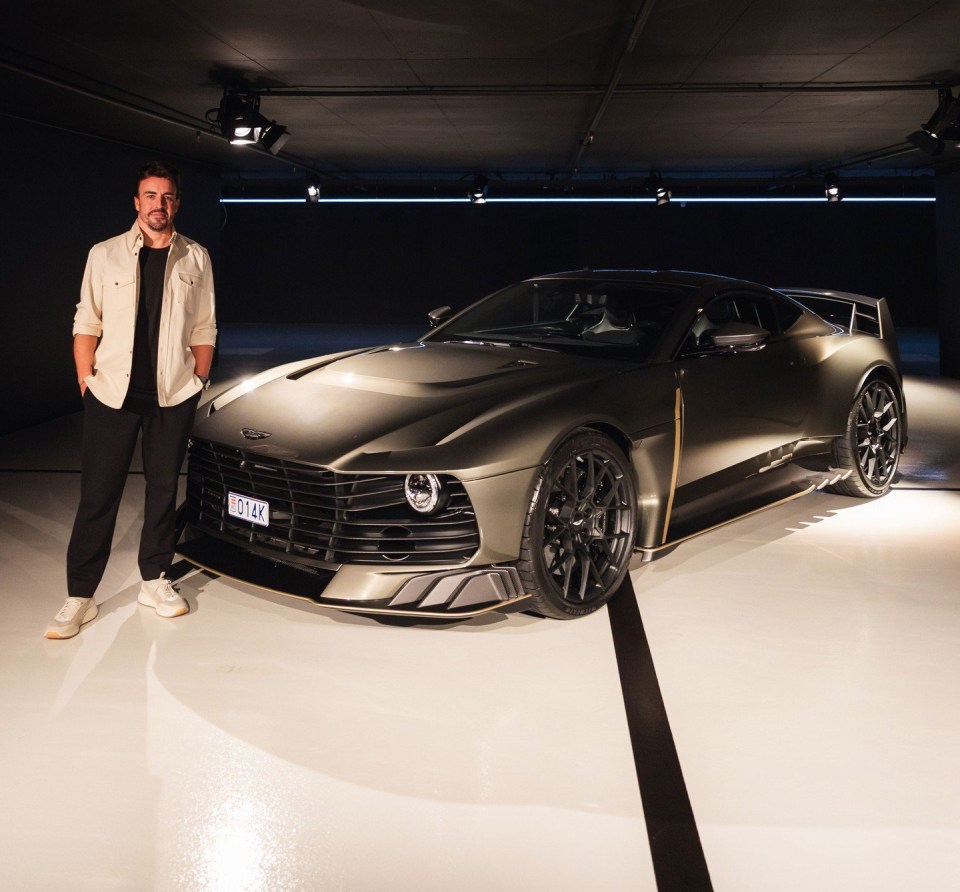 Fernando Alonso standing next to an Aston Martin car.