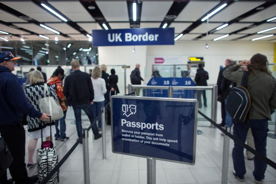 Passengers waiting in line at UK border control.