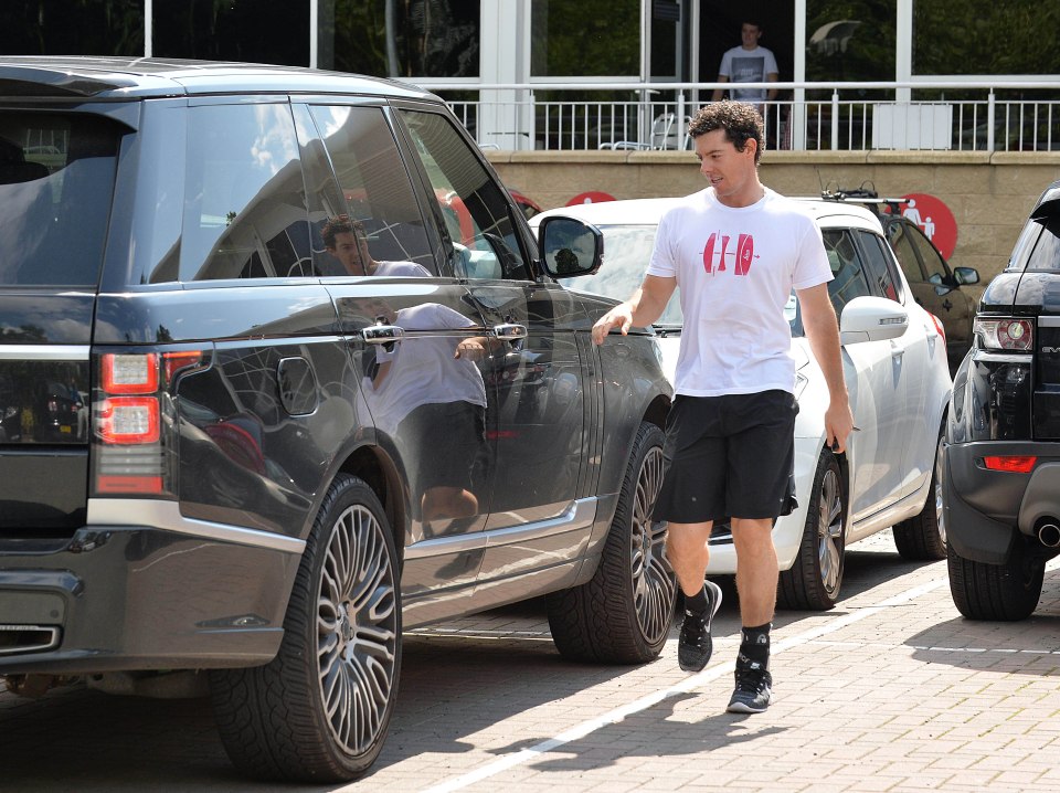 Rory McIlroy walking near his car during rehabilitation from an ankle injury.