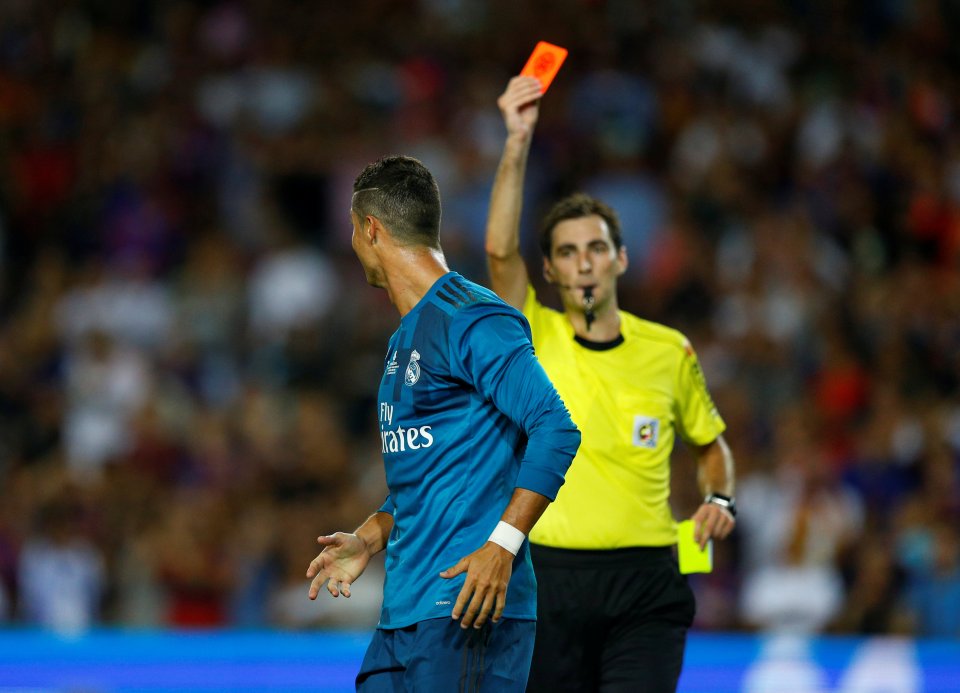 Cristiano Ronaldo receiving a red card from a referee.