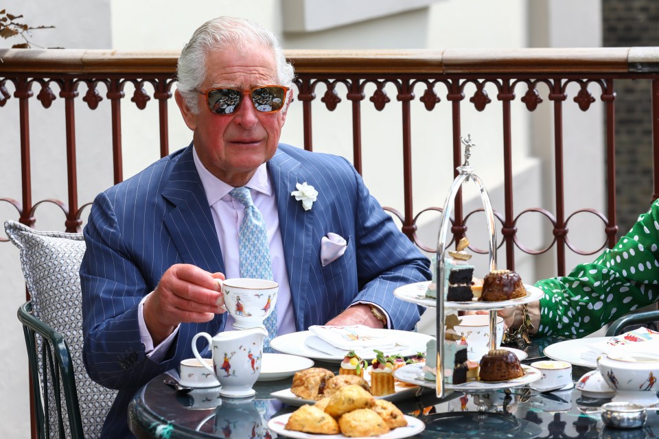 Prince Charles having tea on a terrace.
