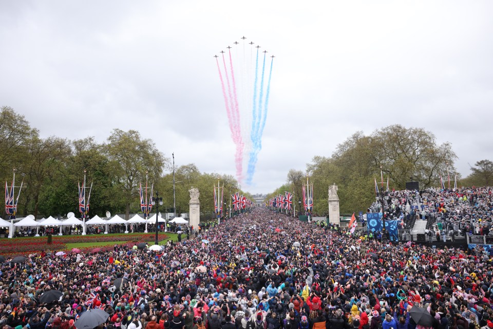 The Red Arrows fly over a large crowd on The Mall during the Coronation of King Charles III.