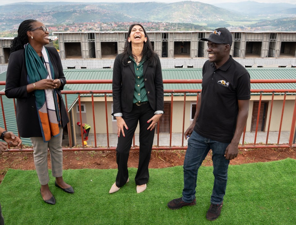 Suella Braverman laughing with two others at a building site in Rwanda.