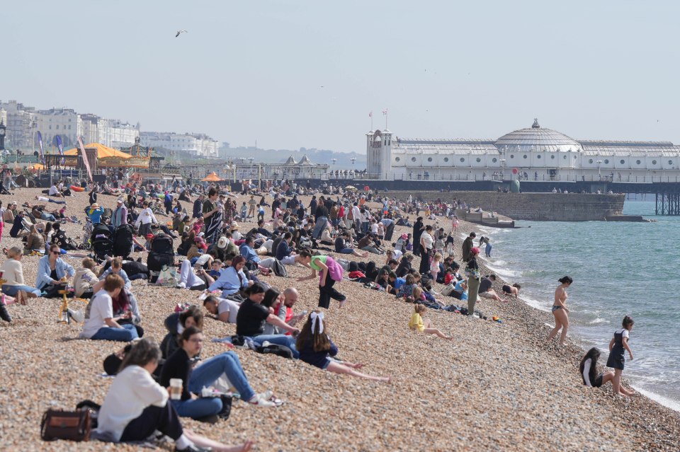 Crowds of people enjoying a sunny day on Brighton Beach.