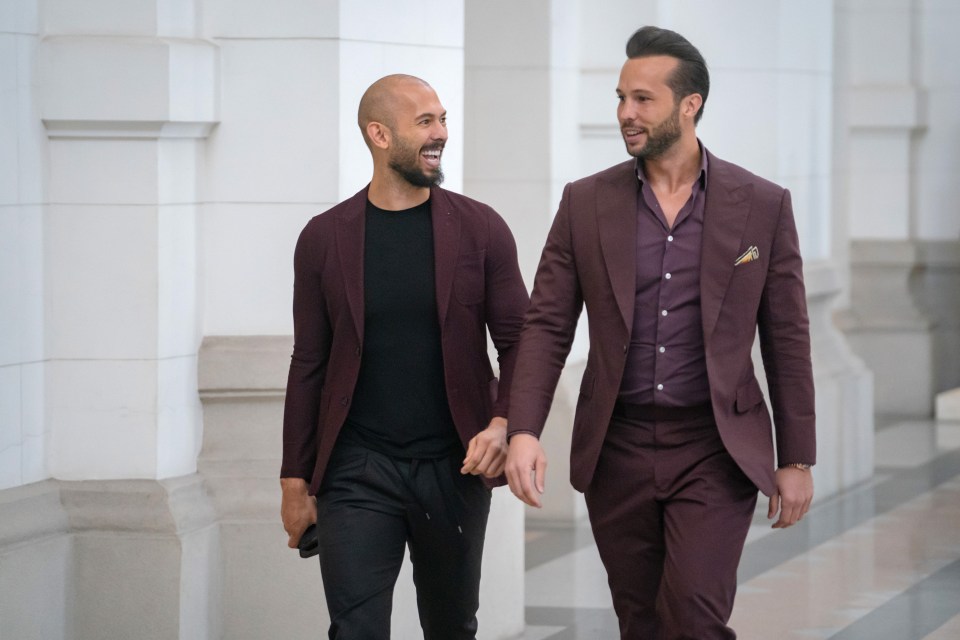 Andrew Tate and his brother Tristan Tate walking in a courthouse.