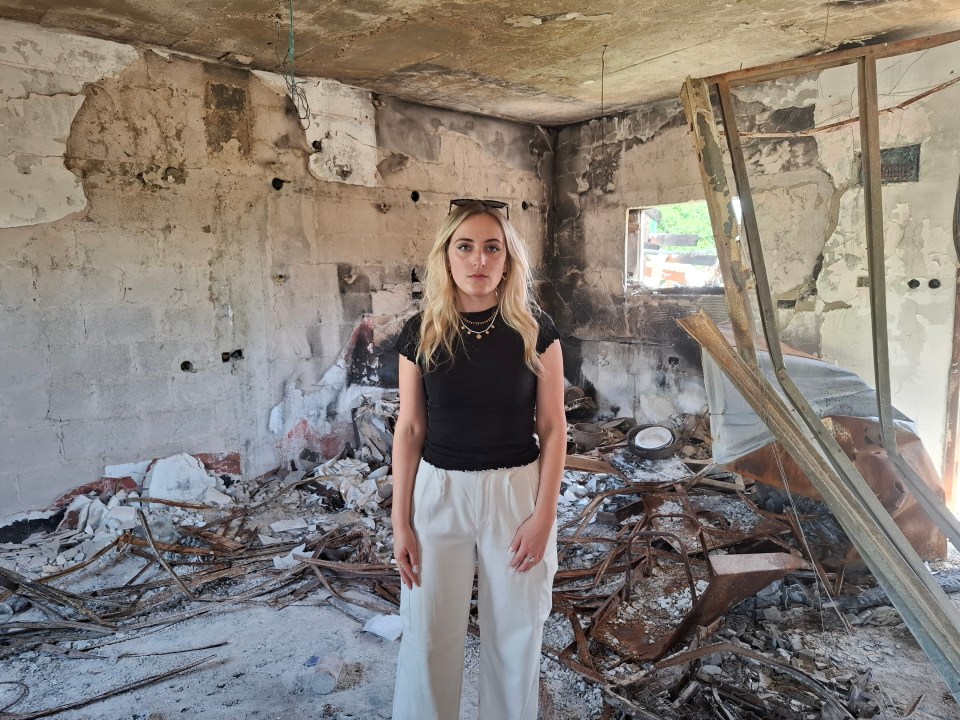 Woman standing in a destroyed building.