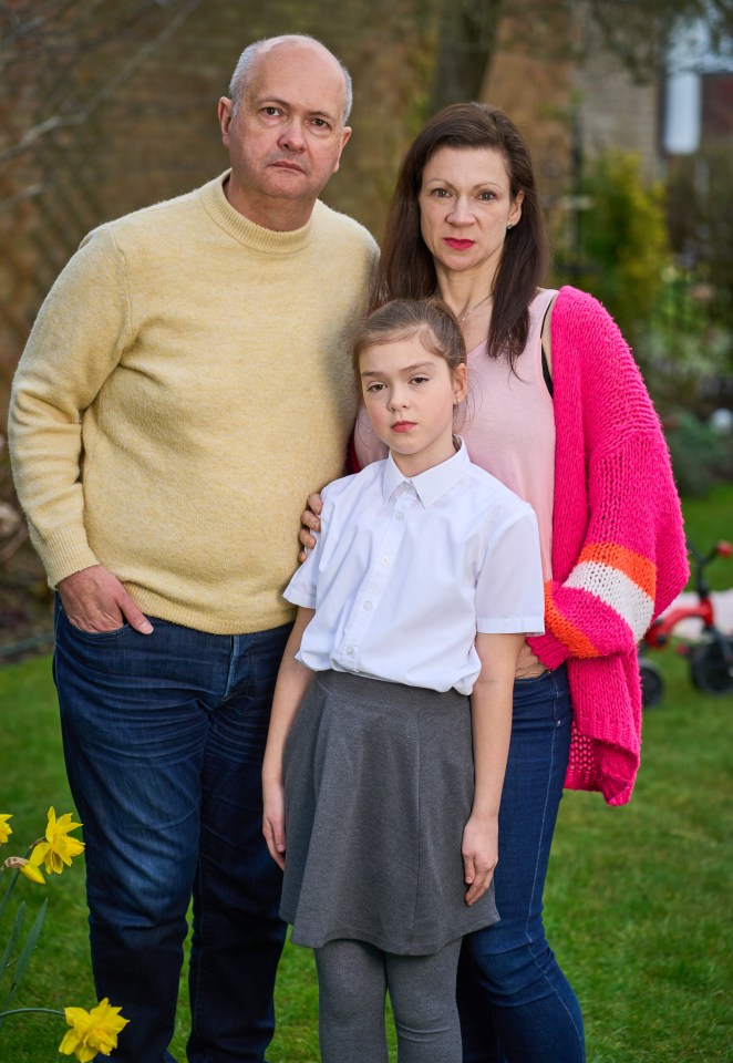 Parents and their daughter stand in their garden.