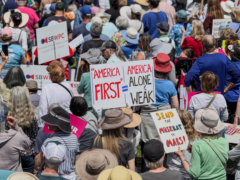 Protestors holding signs at a rally.