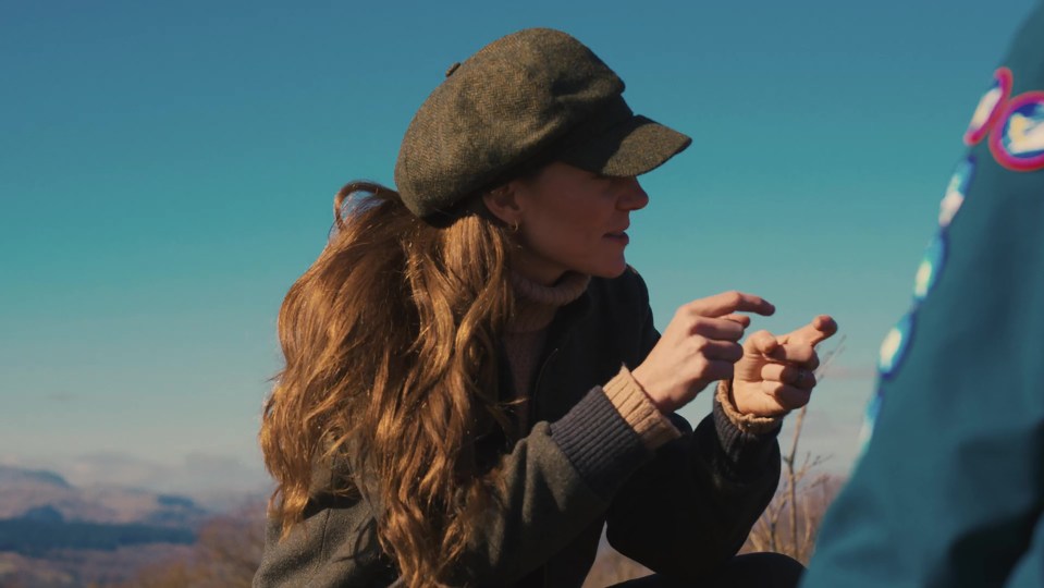 Screengrab of Kate Middleton speaking with a young person outdoors.