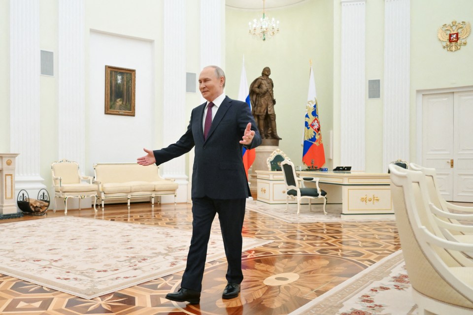Vladimir Putin gesturing during a meeting in the Kremlin.