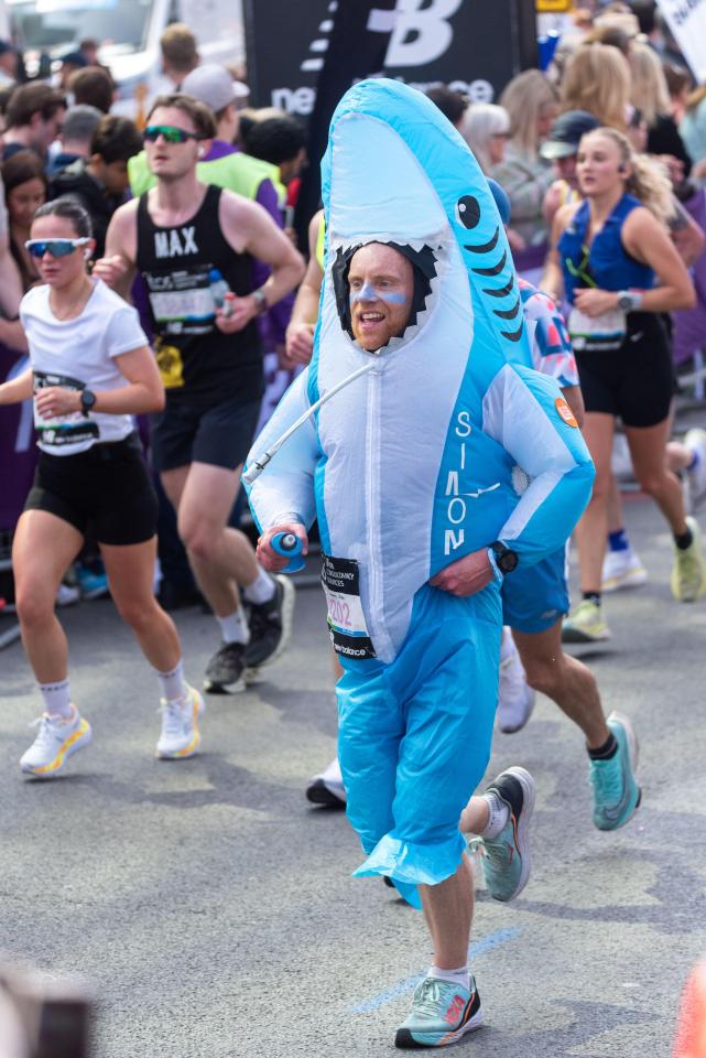 Runner in a shark costume participates in the TCS London Marathon.