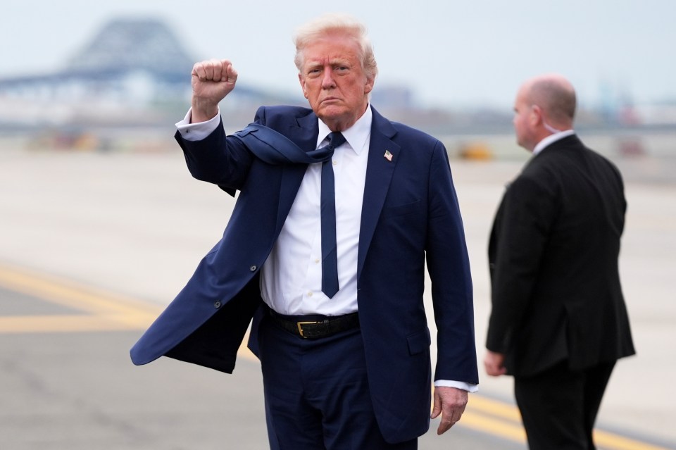 President Trump arriving at an airport, raising his fist.