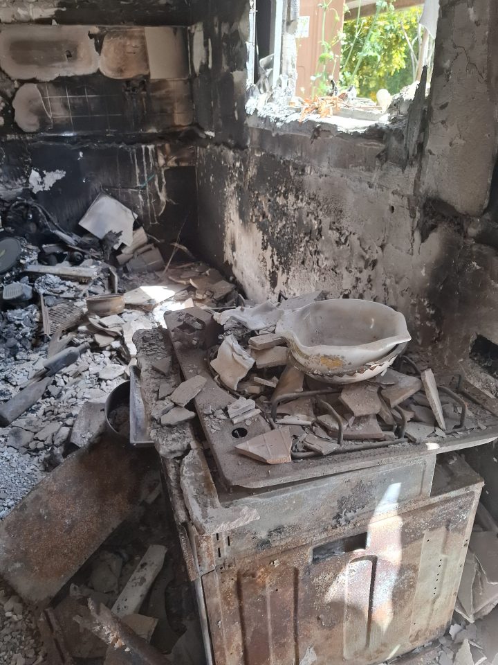 Fire-damaged kitchen stove with broken pottery.