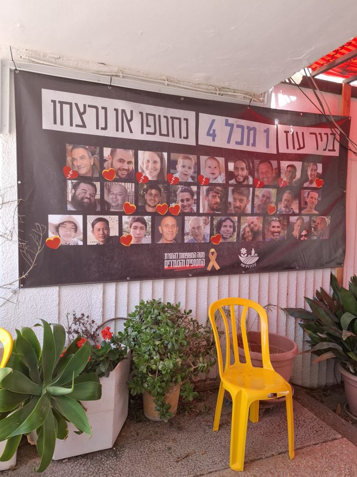 Memorial banner with photos of victims and a yellow chair.