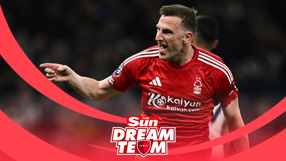 Soccer player in red jersey gesturing during a game, The Sun Dream Team logo overlayed.