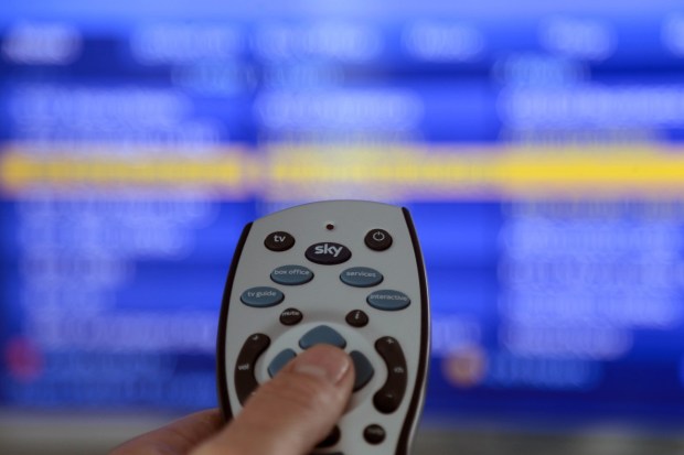 Sky remote control in front of a blurred Sky TV screen.