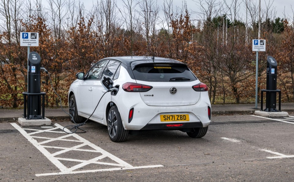 White Vauxhall Corsa electric car charging at a charging station.