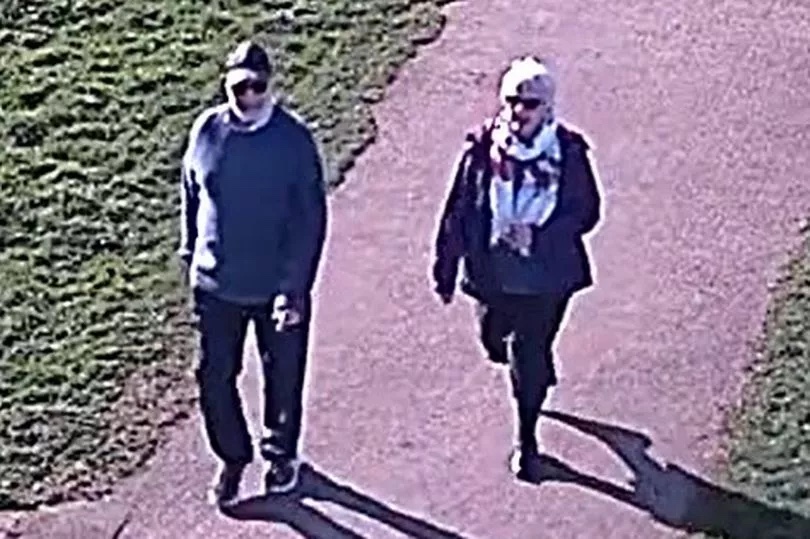 CCTV image of a man and woman walking on a path.