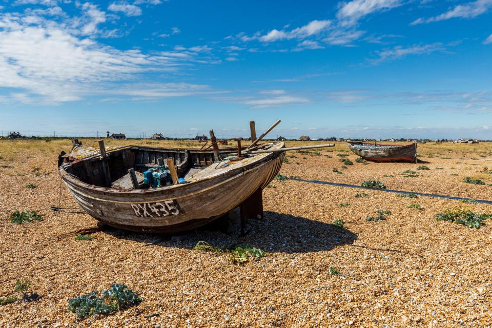 Two old fishing boats on a shingle beach.