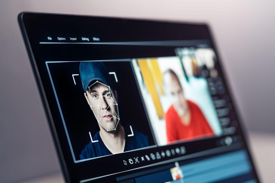 Laptop screen showing video editing software with a face-swap in progress.