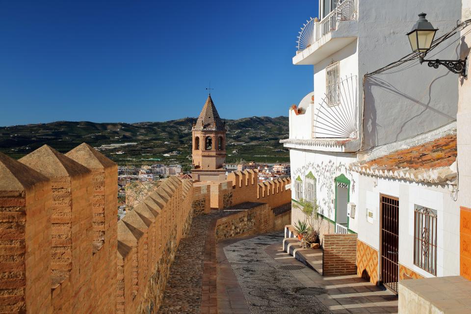 Cobbled alley overlooking Velez Malaga, Spain, with the church of San Juan Bautista in the background.
