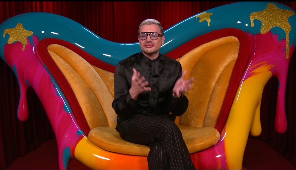 Person sitting in a colorful, abstract chair.