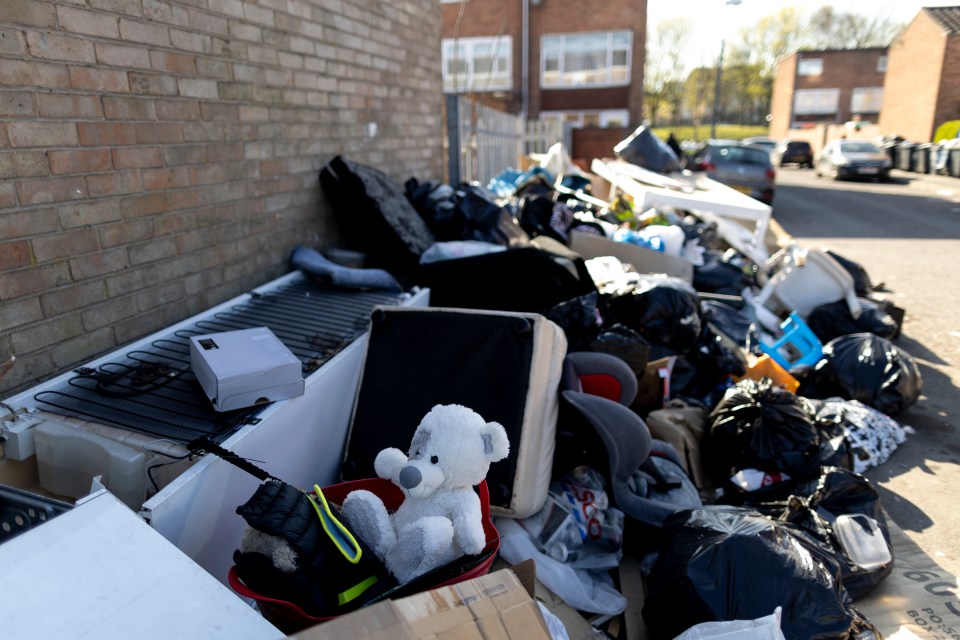 Pile of rubbish and discarded items on a street during a refuse workers' strike.