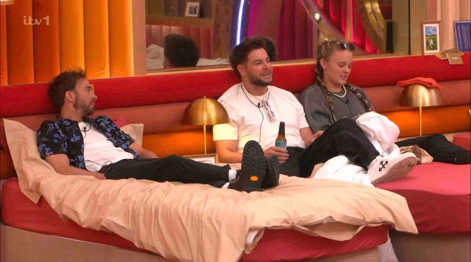 Three contestants relaxing on a bed in the Big Brother house.