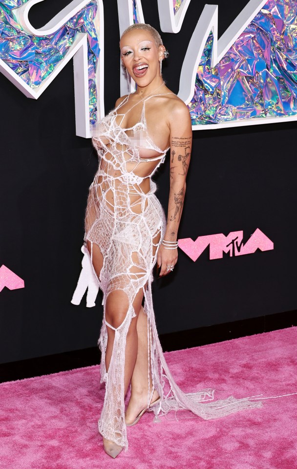 Doja Cat in a revealing white lace dress at an awards show.