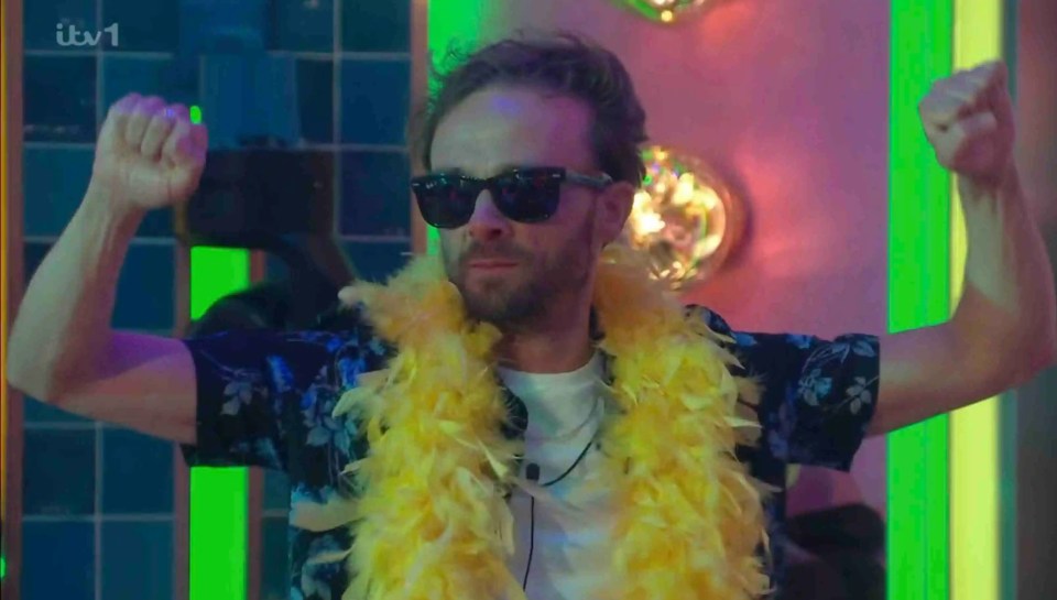 Man in sunglasses and feather boa celebrating.