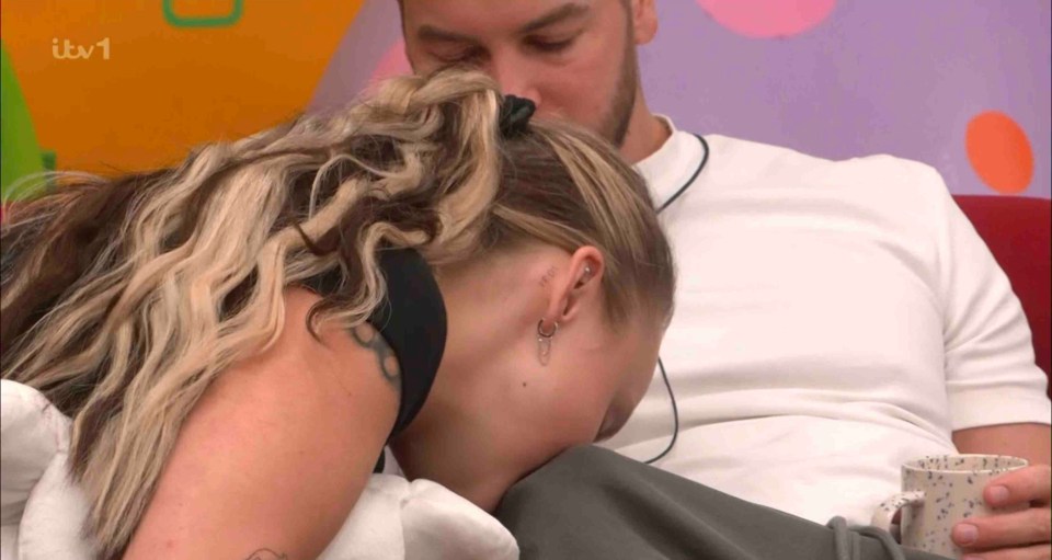 A woman leaning over a man's lap.