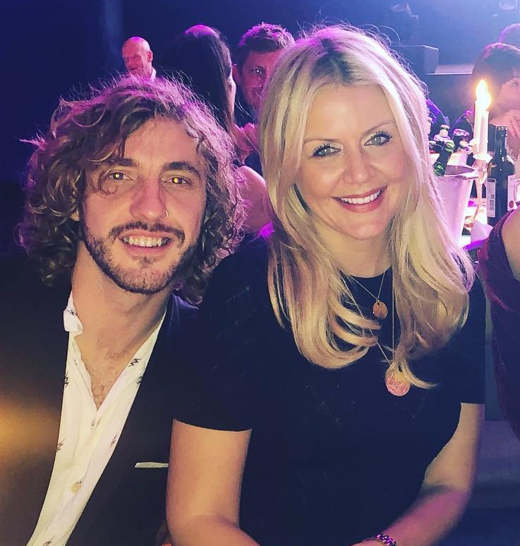 Three people seated at a table at a formal event.