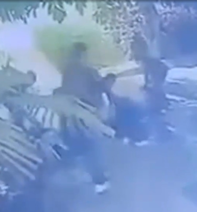Blurry security camera footage of people outside.