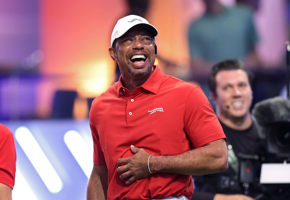 Tiger Woods and Tom Kim laughing during a golf match.