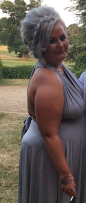Woman in a gray dress outdoors.