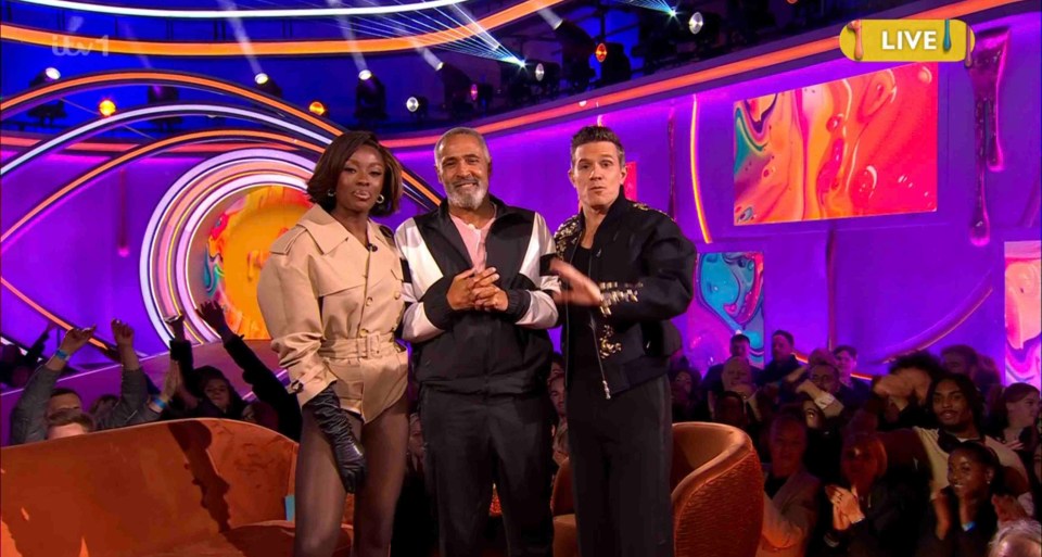 Three television hosts on a brightly lit stage.
