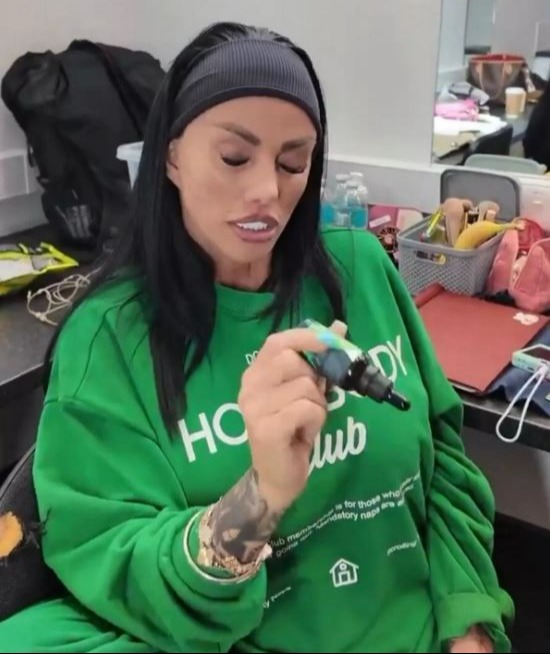 Katie Price holding a small bottle.