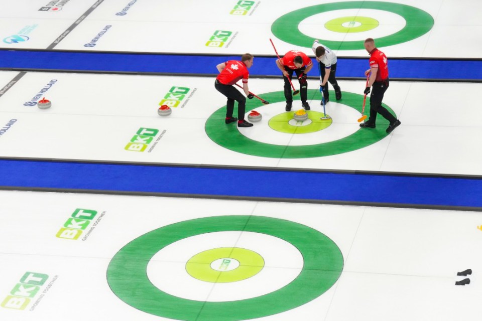 Scotland skip Bruce Mouat sweeps a Scottish stone in the button as Canada's Brett Jacobs, Marc Kennedy and Ben Hebert look on during their teams' session at the men's world curling championship in Moose Jaw, Saskatchewan, Monday, March 31, 2025. (Chris Young/The Canadian Press via AP)