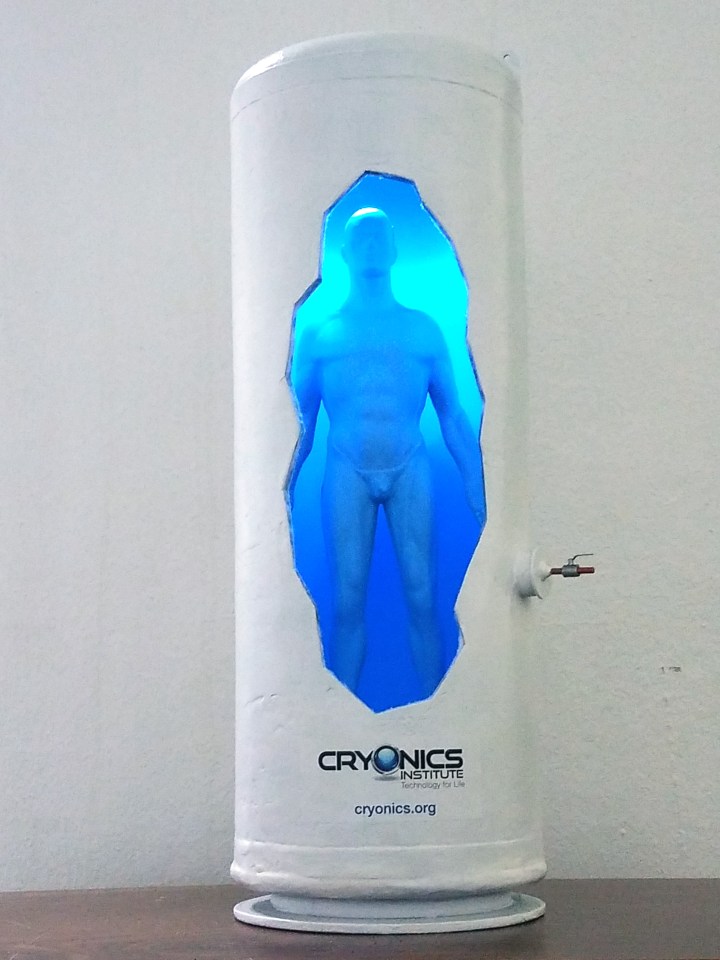 Model of a cryonics institute capsule with a human figure inside.
