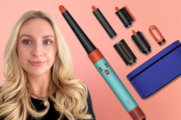 Woman with long blonde hair and a Dyson hair styling tool and attachments.