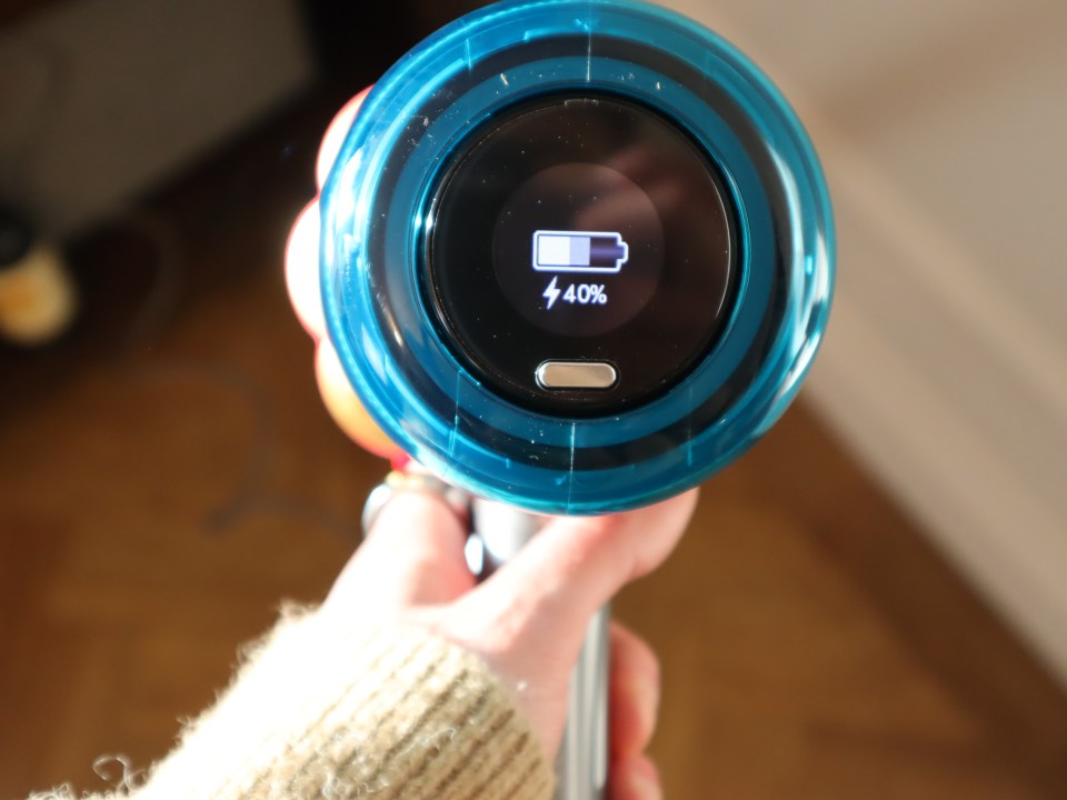 Hand holding The Dyson V12 Detect Slim Absolute with a 40% battery indicator.