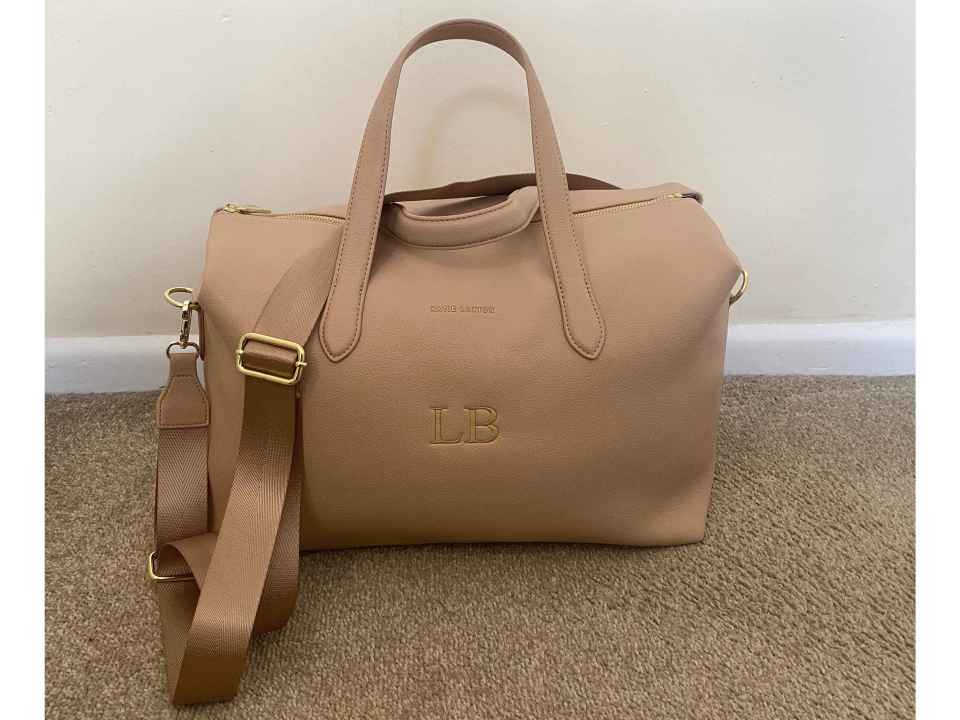 Beige Katie Loxton Milan cabin bag with gold lettering.