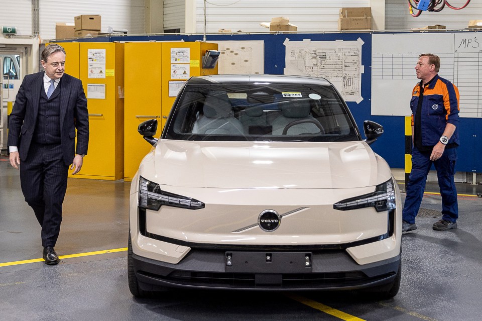 Belgian Prime Minister Bart De Wever observes a Volvo EX30 car at a Volvo factory.