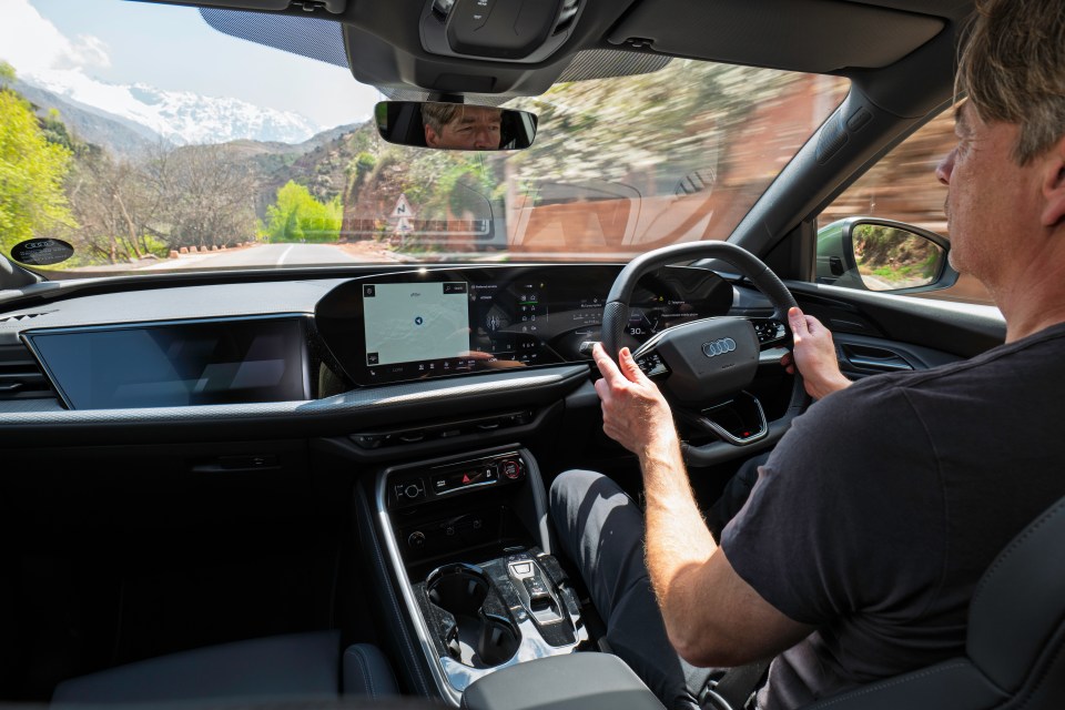 Person driving a car through a mountain pass.