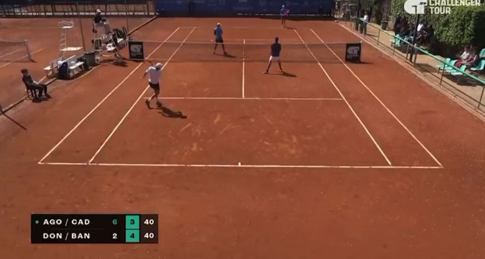 Tennis match in progress on a clay court.