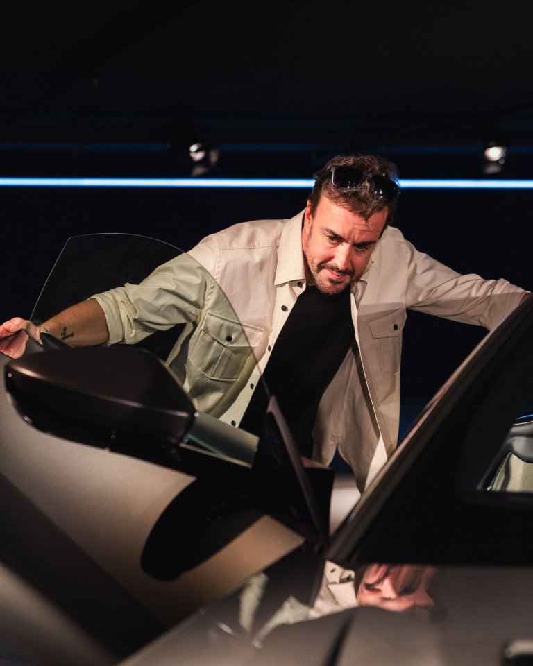 Fernando Alonso inspecting an Aston Martin car.