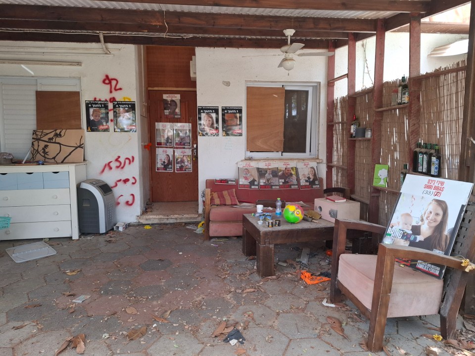Damaged patio of a home in Kibbutz Nir Oz, Israel, with missing persons posters.