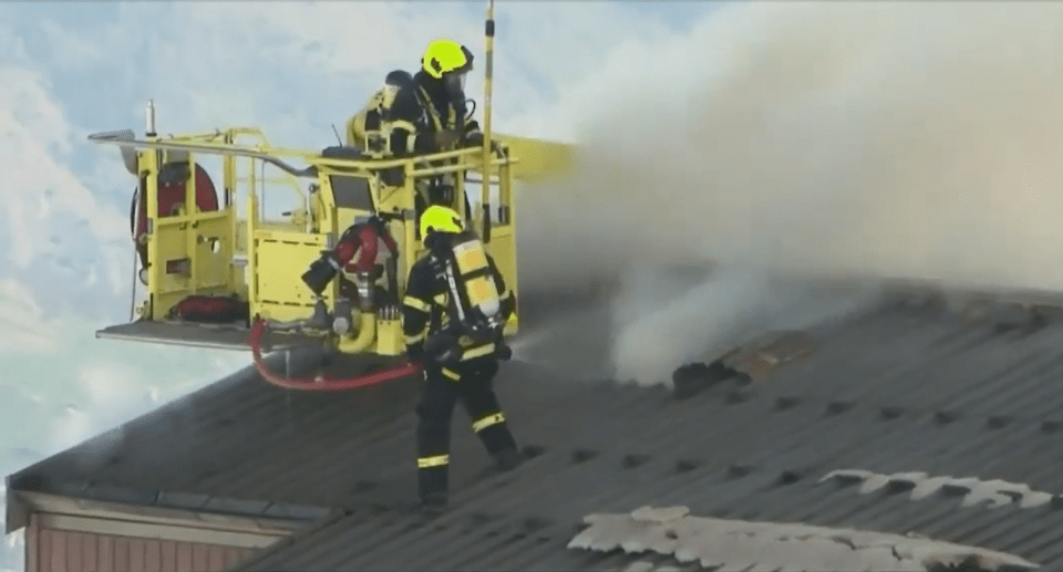 Firefighters extinguishing a roof fire.