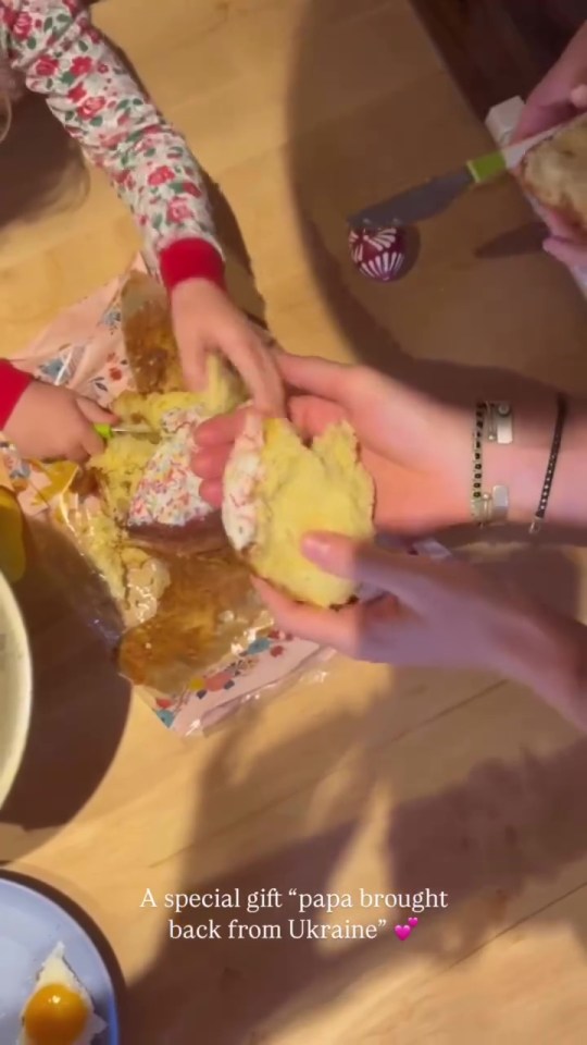 Hands breaking apart a sweet bread brought from Ukraine.