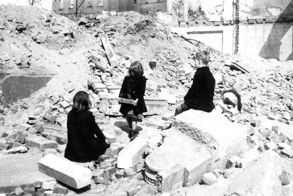 Three children amidst the rubble of bombed-out Leipzig, Germany.